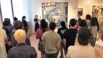 Museum docent leading large group tour