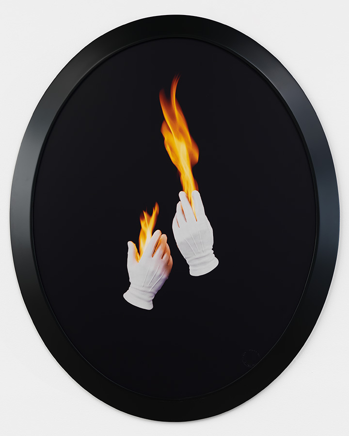 Two white-gloved hands floating in space with fire erupting from the fingers. 