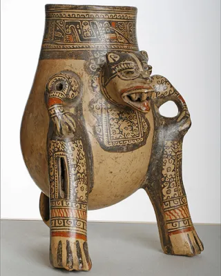 Large beige zoomorphic vessel with animal legs and face as handle.