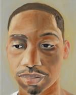 Portrait of young Black man with mustache, goatee, calm expression, short haircut.