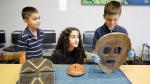 Three children exploring African masks