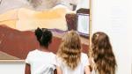 Three young girls enjoying paintings